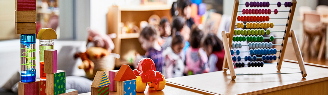 Speelgoed op een kast met op de achtergrond kleine kinderen die aan het spelen zijn