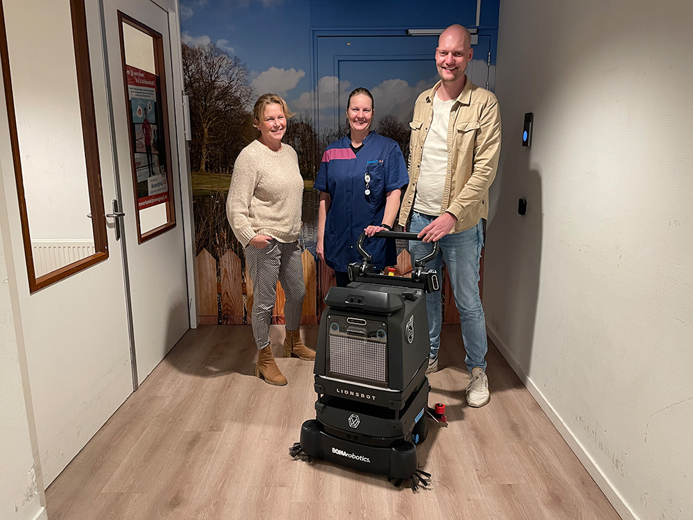 Trois collaborateurs de Beweging 3.0 avec le robot de nettoyage R3.